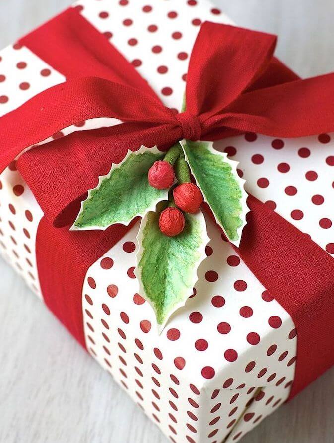 presente decorado com fita vermelha e folhas de papel